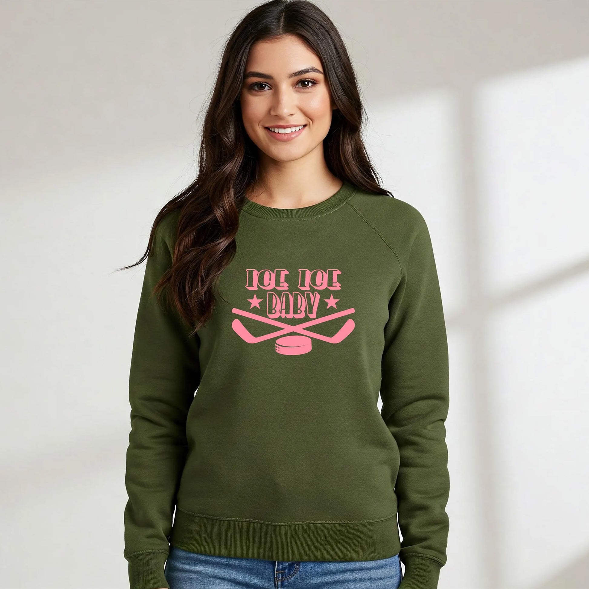 Woman wearing a green sweatshirt with pink text and graphics on a plain background