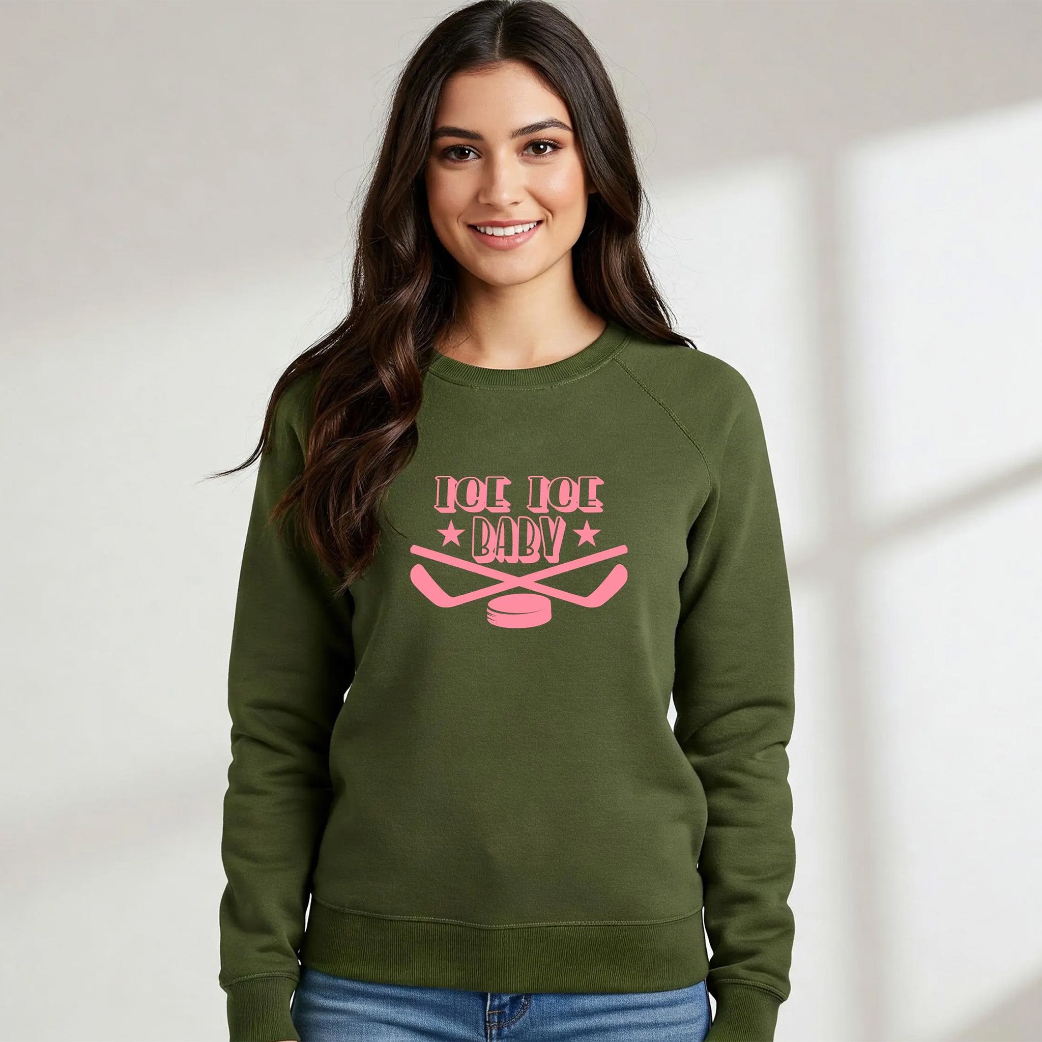 Woman wearing a green sweatshirt with pink text and graphics on a plain background