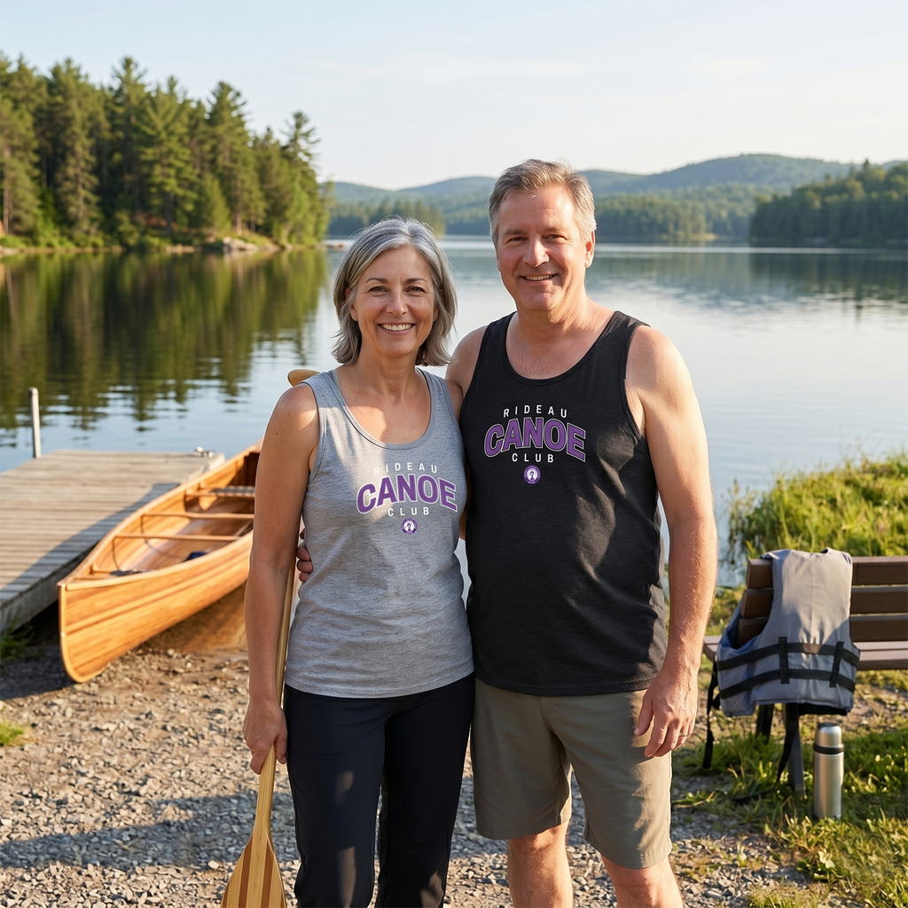 Two people standing by a lake with a canoe and RCC tank tops and dock in the background