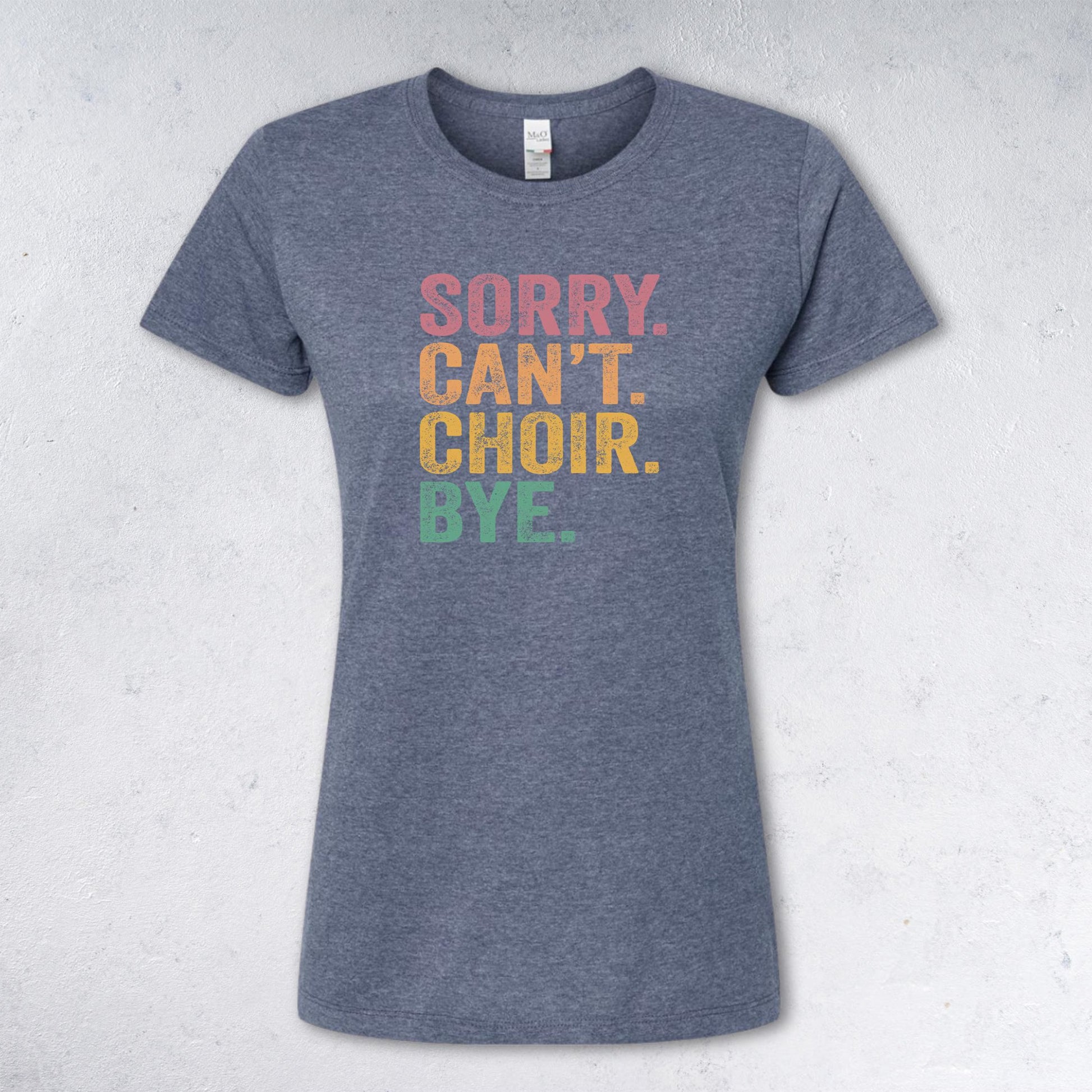 Gray t-shirt with colorful text 'SORRY. CAN'T. CHOIR. BYE.' on a light gray background