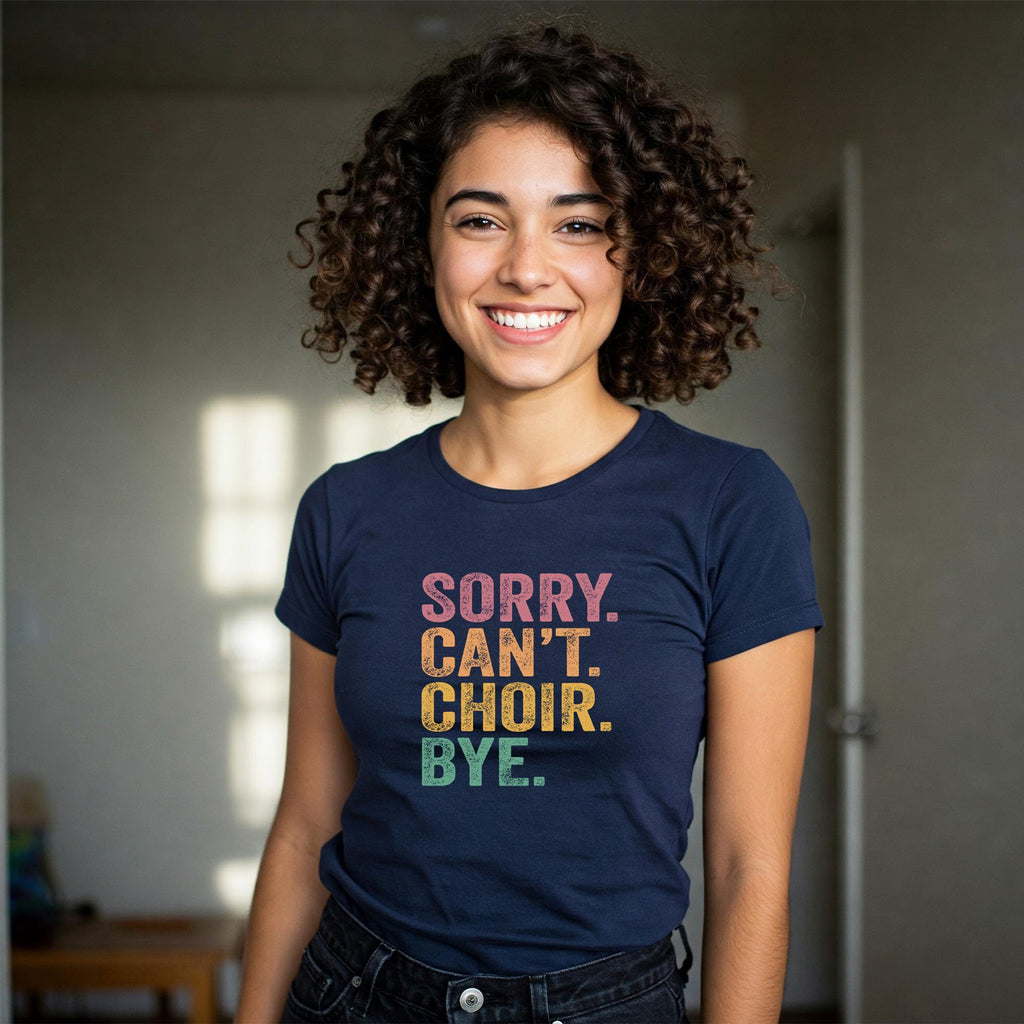Person wearing a navy blue t-shirt with colorful text 'SORRY. CAN'T. CHOIR. BYE.'